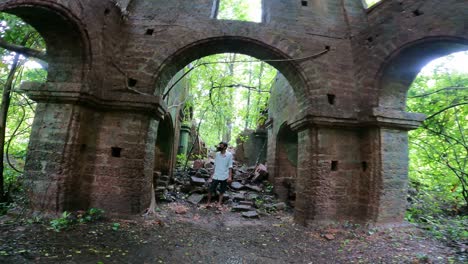 Joven-Explorando-Una-Vieja-Casa-Abandonada-En-Ruinas-En-Goa,-India