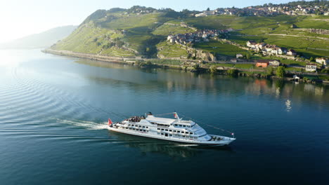 Barco-De-Crucero-De-Lausana-Con-Turistas-Navegando-Tranquilamente-En-El-Lago-Leman-Cerca-Del-Pueblo-De-Rivaz-En-Lavaux,-Suiza
