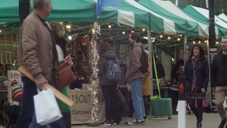 Menschen-Beim-Einkaufen-Und-Spazierengehen-Auf-Einem-Bauernmarkt-In-Der-Stadt-Truro,-Cornwall,-England,-Vereinigtes-Königreich,-Schwenkaufnahme-In-Zeitlupe