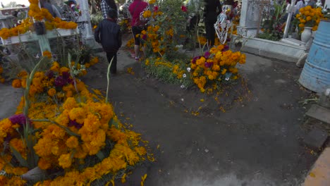 Tombs-adorned-with-cempasuchil-marigold-flowers,-food-and-a-candles-for-the-celebration-of-the-day-of-the-dead-in-Mexico-Puebla-Cholula