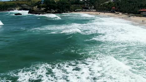 Majestic-ocean-waves-and-Klayar-beach,-East-Java-Indonesia,-aerial-tilt-up