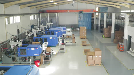 Interior-Of-An-Injection-Molding-Company-With-Modern-Machinery-And-Busy-Employees-At-Work