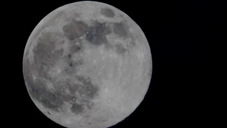 Macro-close-up-of-moving-bright-full-moon-against-dark-sky-at-night---time-lapse-of-cosmos-moonlight