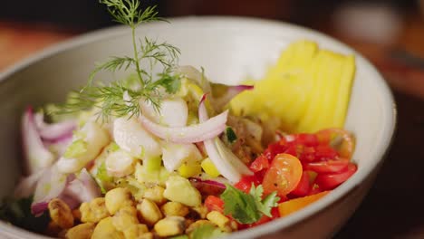 The-complete-dish-of-authentic-traditional-peruvian-ceviche-appetizer,-perfectly-mix-of-ingredients-and-beautifully-garnished-gourmet-food,-handheld-slow-motion-shot