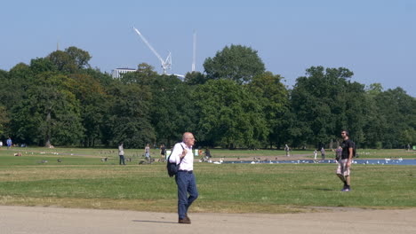 Middle-Age-Man-Walking-Around-Kensington-Garden-Pond-in-London,-United-Kingdom