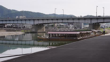 Nagara-gawa-river-and-bridge-with-boats-along-bank,-Gifu-Japan