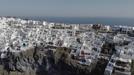 Aerial:-Greek-architecture-and-shadow-of-rich-clifftop-Santorini-homes
