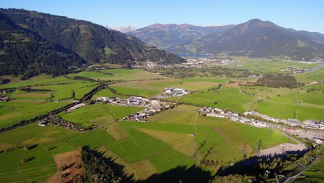 Erstaunliche-Grüne-Felder-Und-Ein-Dorf-Am-Fuße-Des-Berges-In-Kaprun,-Österreich---Luftaufnahme