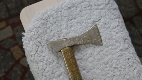 Medium-detail-shot-of-shepherd's-axe,-long-slim-light-combat-axe-of-Eurasian-with-wooden-handle-and-carved-decoration-old-traditional-historical-tool