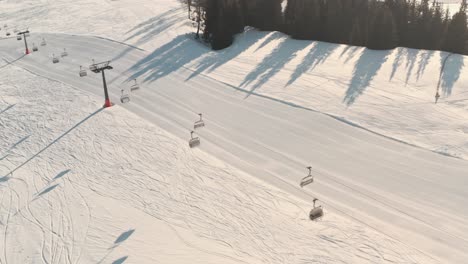 Profile-drone-shot-of-empty-ski-lifts-over-fresh-ski-slope