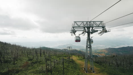 Cable-Cars-Traveling-On-Ropeway-Over-Green-Landscape-In-Zao,-Miyagi,-Japan