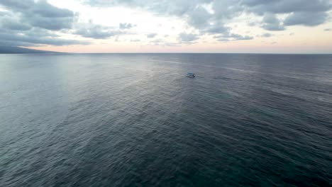 Aerial-view-of-boat-on-open-ocean-at-sunset