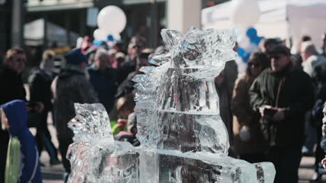 Static-shot-of-crowd-looking-at-horse-sculpture-made-of-ice