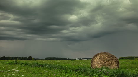 Green-Meadows-With-Hay-Roll-Over-Clouded-Sky-In-Rural-Farm