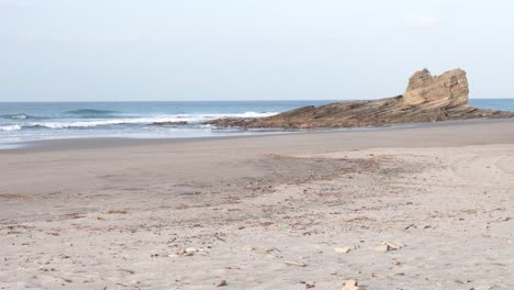 Popoyo-Beach-Nicaragua-Con-Formaciones-Rocosas-Oceánicas-Golpeadas-Por-Las-Olas,-Tiro-Ancho-De-Mano