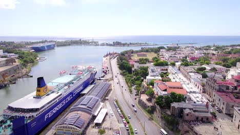 Aerial-forward-along-canal-of-Santo-Domingo-port-with-ferry-boat-anchored-at-pier