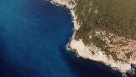 Hill-island-with-rocky-cliff-and-blue-sea-water-at-Porto-Katsiki,-Lefkada,-Greece---aerial-drone-flying-top-shot