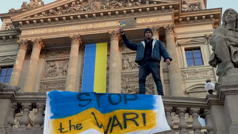 Protester-against-war-in-Ukraine-standing-on-a-balustrade,-Prague