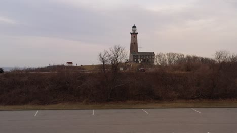 A-low-angle-drone-view-of-the-Montauk-lighthouse-during-a-cloudy-sunset