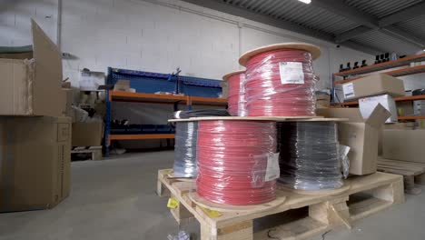 Positive-and-negative-electric-wire-spools-used-for-solar-installation-on-a-pallet-crate,-Orbit-around-shot
