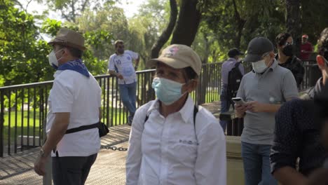 An-elder-man-stands-in-the-street-with-protective-face-mask---slow-motion