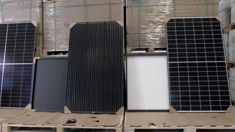 Assorted-solar-panels-for-roof-installation-at-a-warehouse,-Dolly-left-shot