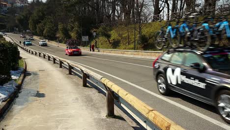 cycling-race-team-cars-pass-on-the-road-with-bicycles-on-their-roofs
