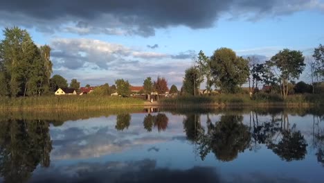 1-million-$-aerial-drone-flight-of-ma-lonely-blond-girl-in-pink-summer-dress-mirroring-at
summer-sunset-in-a-lake-at-small-village-in-Brandenburg-Germany