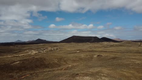 Drone-shot-flying-over-lava-fields-and-volcanic-plains-in-Lanzarote