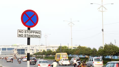 POV-of-the-sign-board-showing-"no-stopping-no-standing"-to-the-people-in-vehicles-to-follow-the-traffic-rules-and-safety-with-vehicles-moving-on-the-highway-road-background