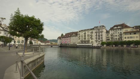 Establishing-shot-of-Lucerne-Old-Town-picturesque-buildings-next-to-Reuss-River-at-daytime,-Switzerland