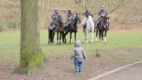 Niño-Viendo-Caballos-De-La-Policía-Montada-En-El-Parque-En-Bruselas,-Bélgica