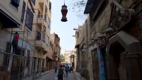 People-walking-along-charming-alley,-Islamic-Cairo,-Cairo,-Egypt