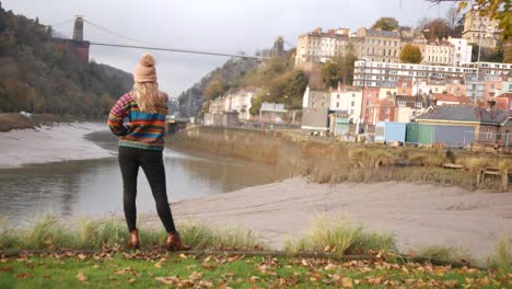 woman-standing-by-the-riverside-of-Bristol-looking-at-the-suspension-bridge