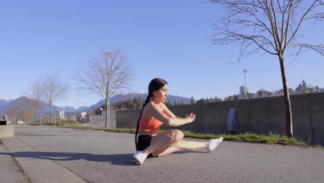 Young-flexible-athletic-woman-doing-side-split-squat-exercise