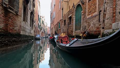 Low-angle-water-surface-pov-of-gondola-floating-on-Venetian-canal,-Venice-in-Italy