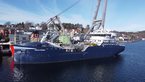Der-Fischtransporter-Ronja-Strand-Der-Firma-Solvtrans-Liegt-Längsseits-Im-Hafen-Von-Leirvik-In-Norwegen-–-Wunderschöne-Luftaufnahme-Mit-Sonnenlicht-Und-Reflexionen-Auf-Dem-Schiffsrumpf