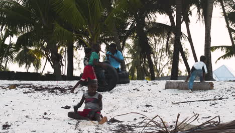 Afrikanisches-Kind-Versucht,-Am-Strand-Einen-Handstand-Zu-Machen,-Andere-Kinder-Spielen-Dahinter