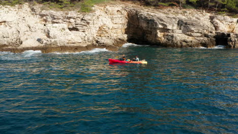 -Kayaking-In-Sea-Waters-Near-The-Cliffs-And-Caves-In-Pula,-Croatia---wide-shot