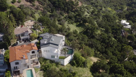 Aerial-shot-of-a-white-hillside-mansion-in-Sherman-Oaks-California