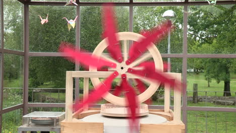 Artistic-wooden-structure,-which-makes-the-stone-of-the-caster-mill-move,-with-a-red-helix-rotating
