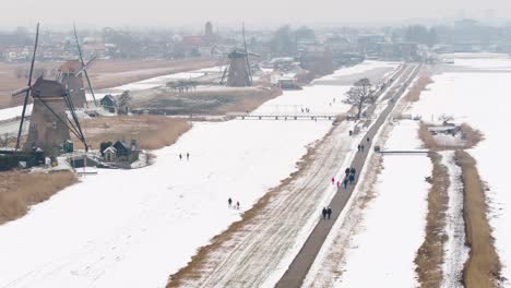 Niederländische-Eisläufer-An-Den-Alten-Windmühlen-Des-Kinderdijk-Weltkulturerbes-An-Einem-Kalten-Wintertag
