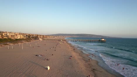 Fly-Away-At-Sandy-Beach-With-Many-Tourists-In-Manhattan-Beach-Pier,-California-USA
