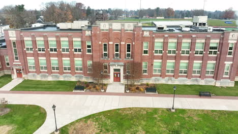 Aerial-establishing-shot-of-two-story-brick-school-on-college-university-campus
