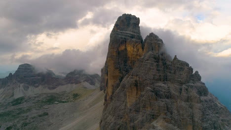 Aerial-view-across-clouds-over-majestic-Tre-Cime-mountain-peak-rock-formation-scenery-in-South-Tyrol-Dolomites