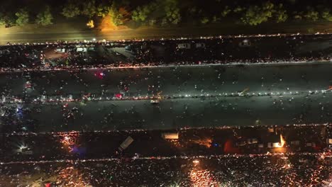 Aerial-Birds-Eye-View-Of-People-Walking-Along-Road-In-Karachi-At-Night-For-PTI-Party-Rally-On-16-April-2022
