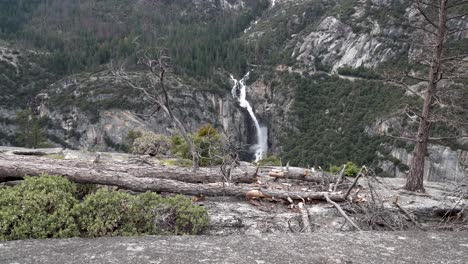 Acercándose-A-Sentinel-Falls-En-El-Parque-Nacional-De-Yosemite-California-Desde-Un-Acantilado-Con-Un-árbol-Caído,-Dolly-Aéreo-En-Tiro