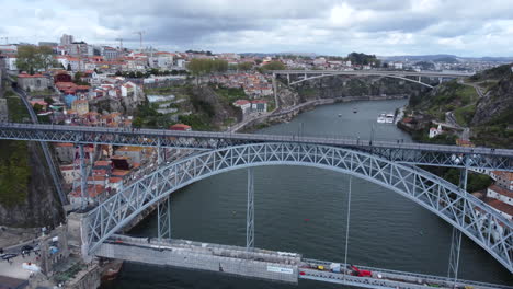 Overhead-shot-of-Dom-Luís-I-Bridge-with-Pedestrians-on-the-Elevated-Walkway,-Aerial-Tilt-Down