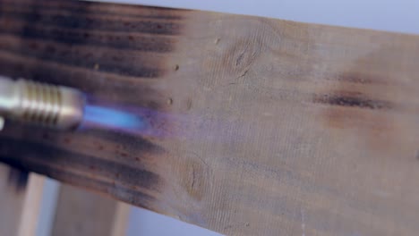 Person-Using-Butane-Blowtorch-To-Burnt-The-Surface-Of-Wooden-Pallet