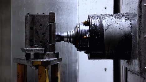 Close-up-shot-of-the-workshop-of-a-automotive-factory-with-CNC-machine-working-with-drops-of-water-pouring-over-it